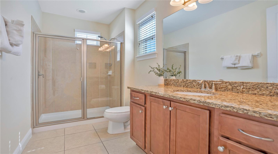 Well-appointed private bath with granite counters and spacious layout