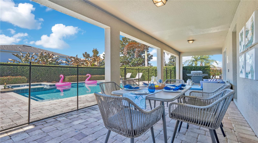 Extended covered lanai with multiple seating areas, perfect for hosting guests in a private retreat setting.