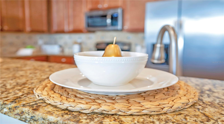 Granite countertops and stainless appliances create a polished, upscale cooking space.