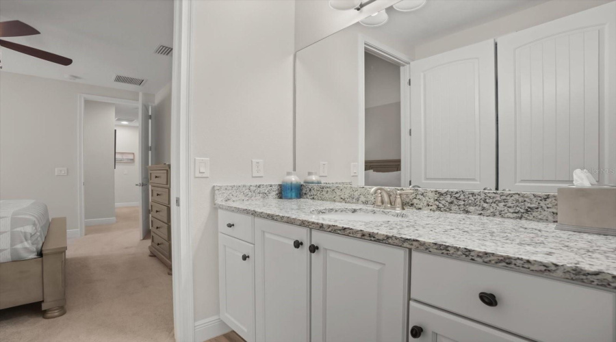 Double vanity bathroom with granite countertops and ample storage space.