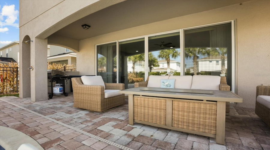 Covered outdoor lanai providing shaded seating and seamless indoor outdoor living.