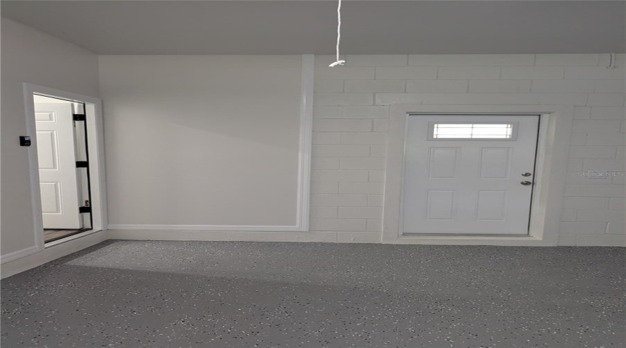 HOUSE ENTRANCE ON LEFT FROM GARAGE.  DOOR WITH WINDOW OPENS ONTO THE REAR PATIO.