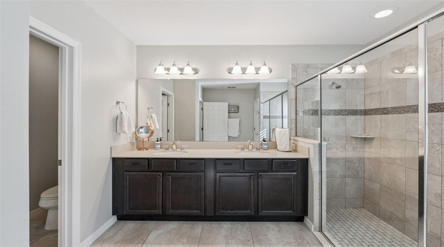 Primary Bathroom with dual vanities and a large shower