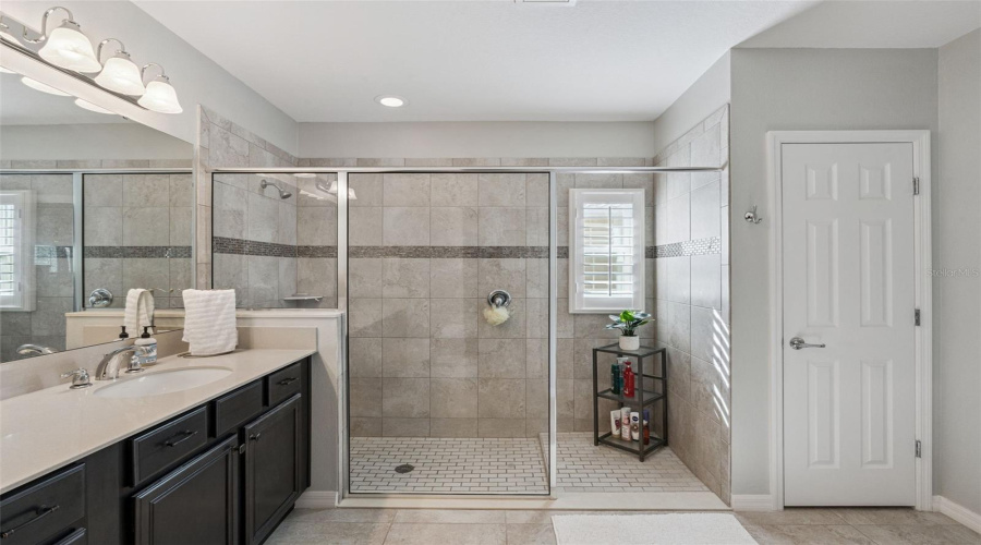 Primary Bathroom with dual vanities and a large shower