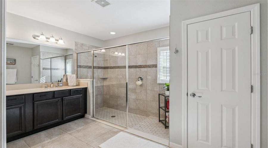 Primary Bathroom with dual vanities and a large shower