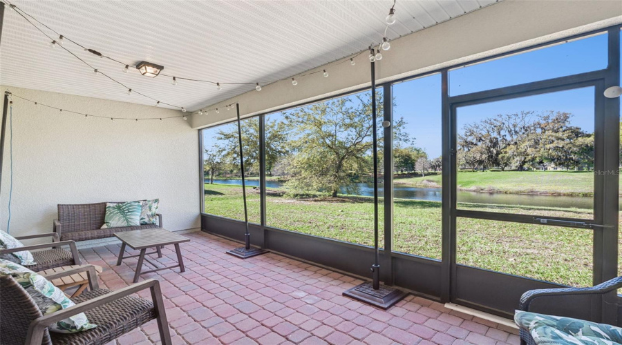 Screened-in lanai with serene water views—perfect for relaxing and entertaining