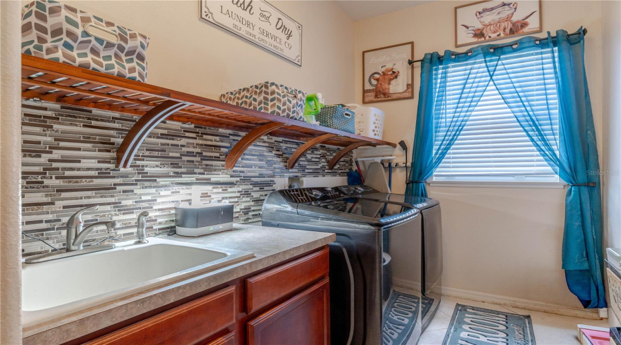 Laundry room with utility sink and shelving