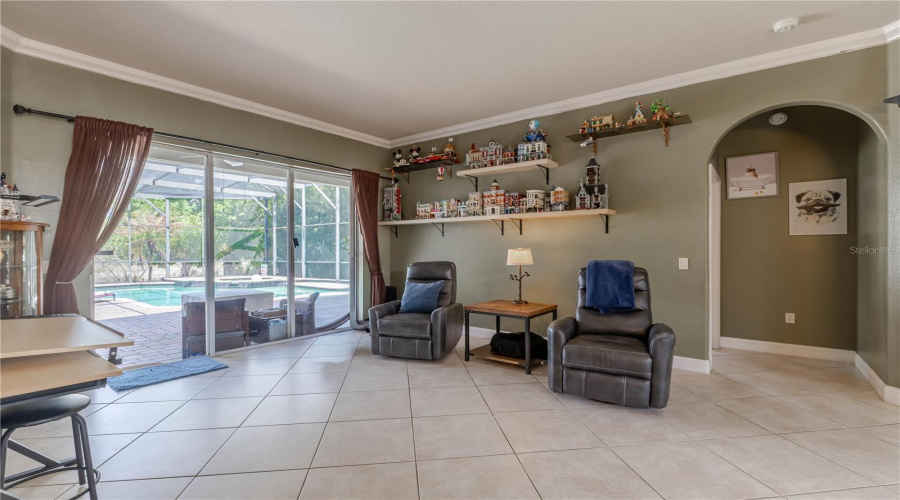 Large sliders out to pool deck, primary suite and office/den to the right