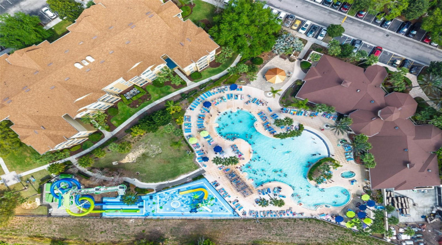 Areial_showing_community_water_slide_pool_with_clubhouse_to_right_with_dark_brown_roof