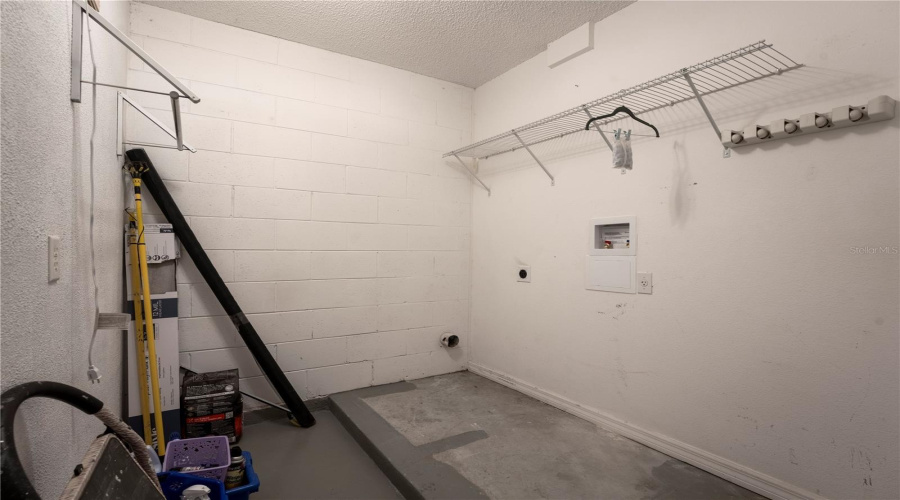 Enclosed laundry room in the garage off the kitchen
