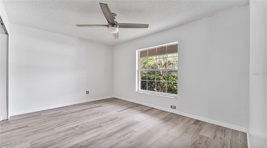 Bedroom 3 at the front of the house with ceiling fan and NEW luxury vinyl flooring