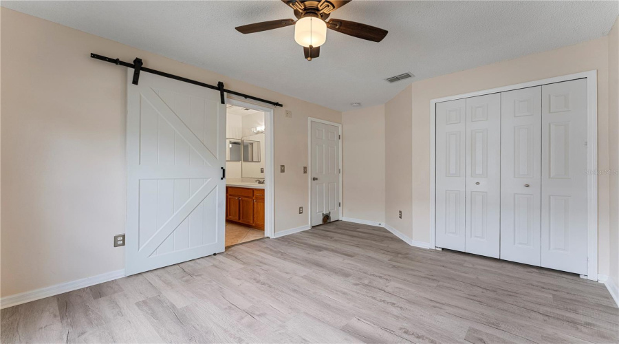 Bedroom 4 with barn door opening to the Jack and Jill bathroom and NEW luxury vinyl floor