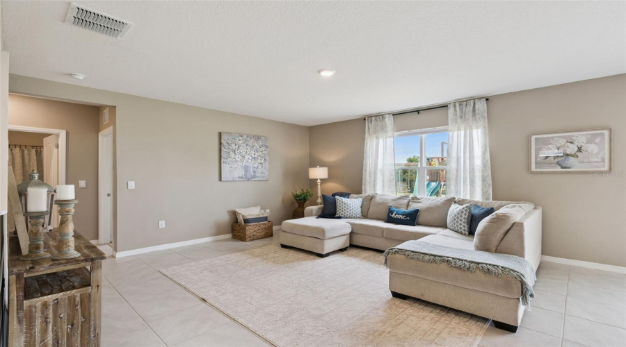 At the back of the house to the left of the foyer is a nice size family room which overlooks the backyard