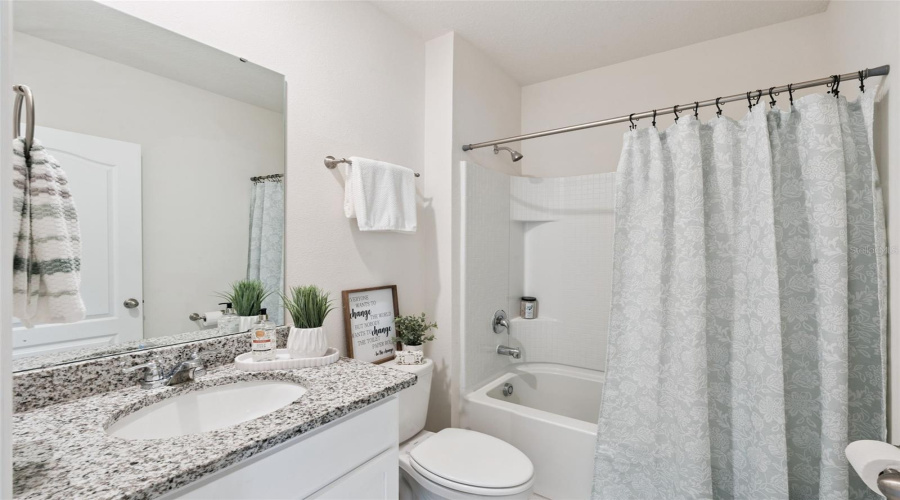 The downstairs full bath can be found off the family, garage and guest bedroom.