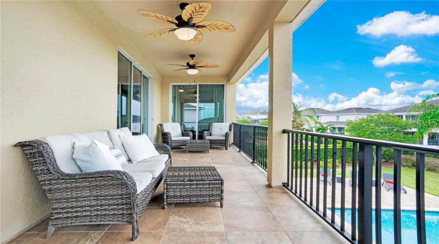 Covered second-floor balcony with comfortable lounge seating and views perfect for Disney fireworks and rocket launches