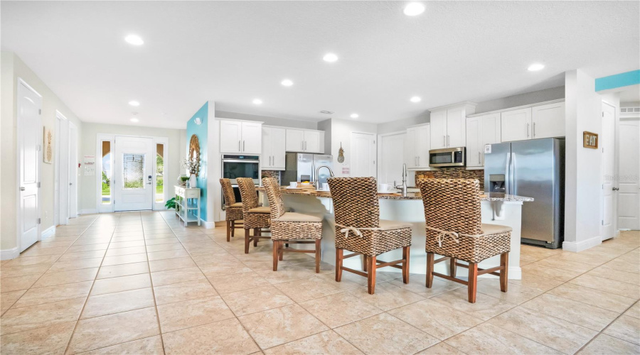 Bright open-concept main living area designed for entertaining large groups with seamless flow between the kitchen, dining, and gathering spaces