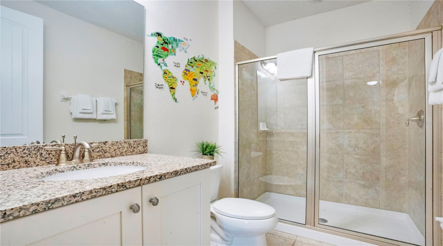 Well-appointed ensuite bath (#6) with granite vanity and tiled walk-in shower