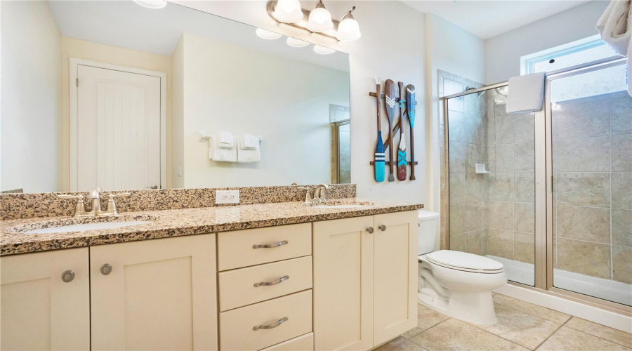 Luxury ensuite bathroom (#7) with dual vanities, granite counters, and oversized shower