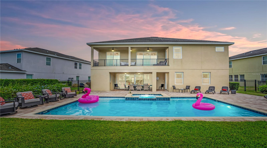 Expansive backyard retreat with heated pool and spa offering the perfect setting for relaxing after a day at Disney or enjoying evenings under the Florida sky