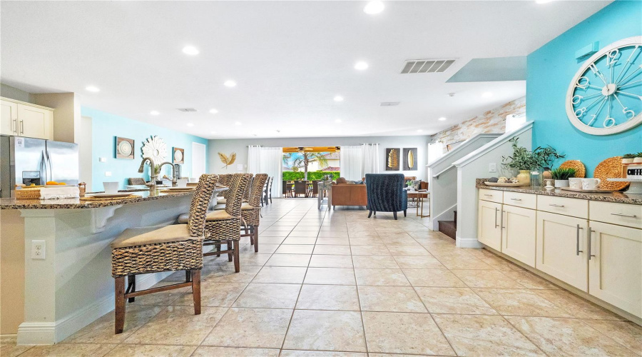 Chef-inspired gourmet kitchen featuring granite countertops, oversized island seating, dual refrigerators, dual dishwashers, and abundant cabinetry for high-capacity hosting