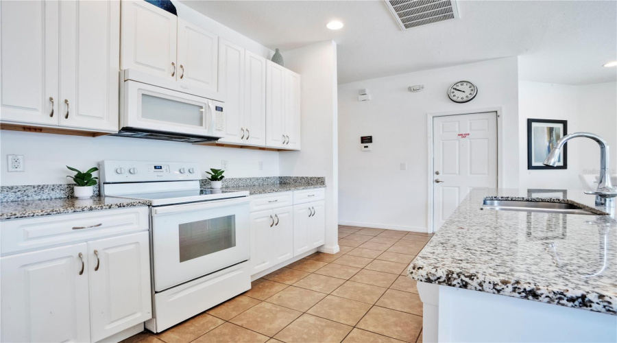 Kitchen with granite counters, ample storage, and modern layout.