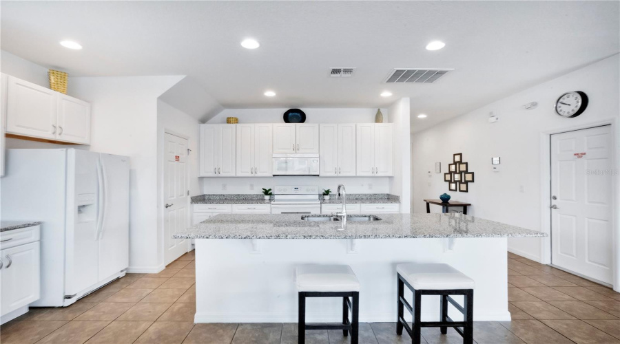 Kitchen with island seating and adjacent dining space.