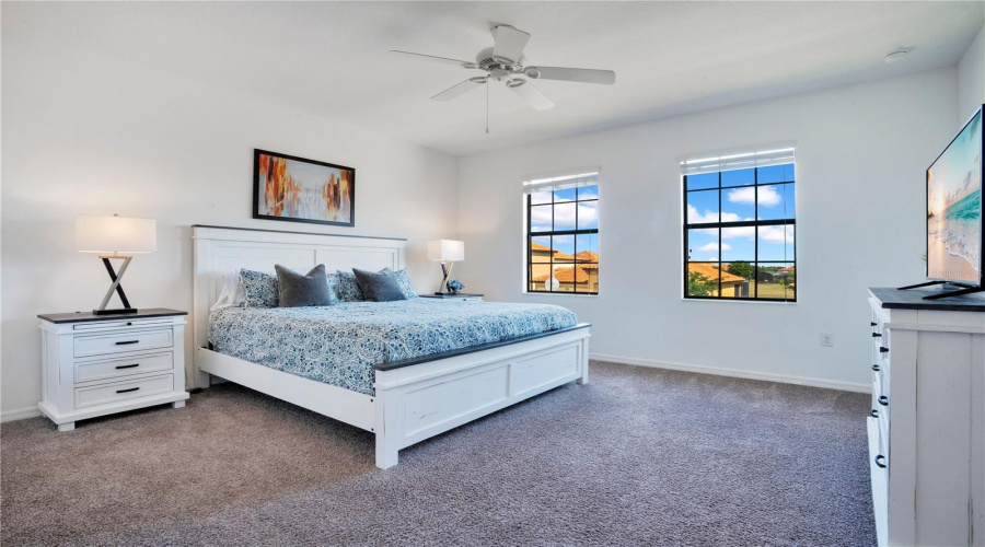 Spacious primary bedroom with large windows and privacy.