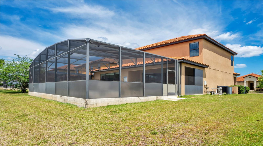 Rear exterior with screened pool enclosure and private yard.