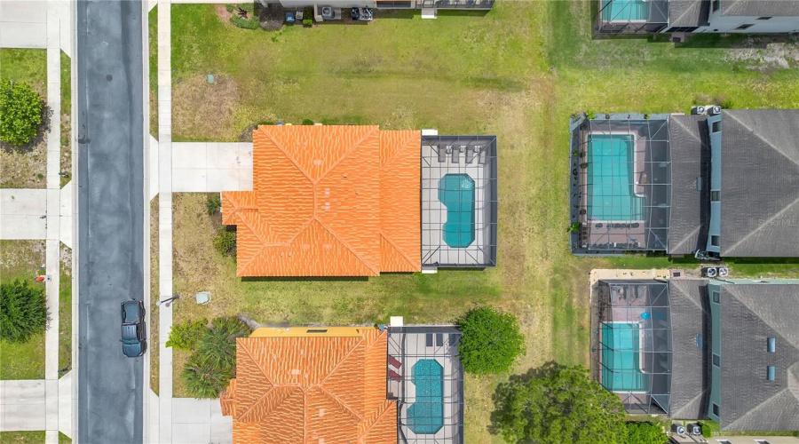 Top down aerial of home with private pool and screened enclosure.