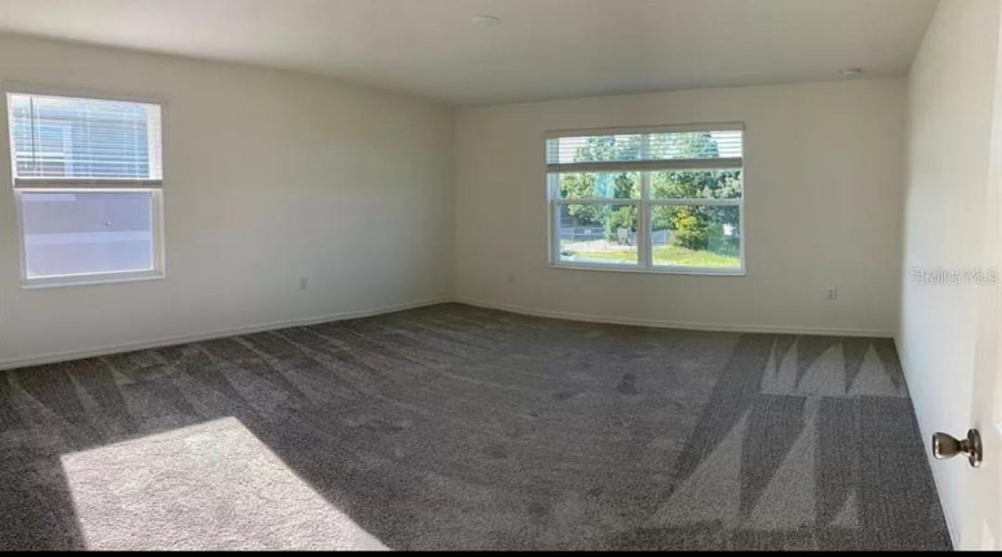 “Spacious primary bedroom featuring a private bathroom.”