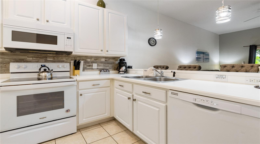 Bright and airy kitchen benfits from an abundance of kitchen cabinets and counter space