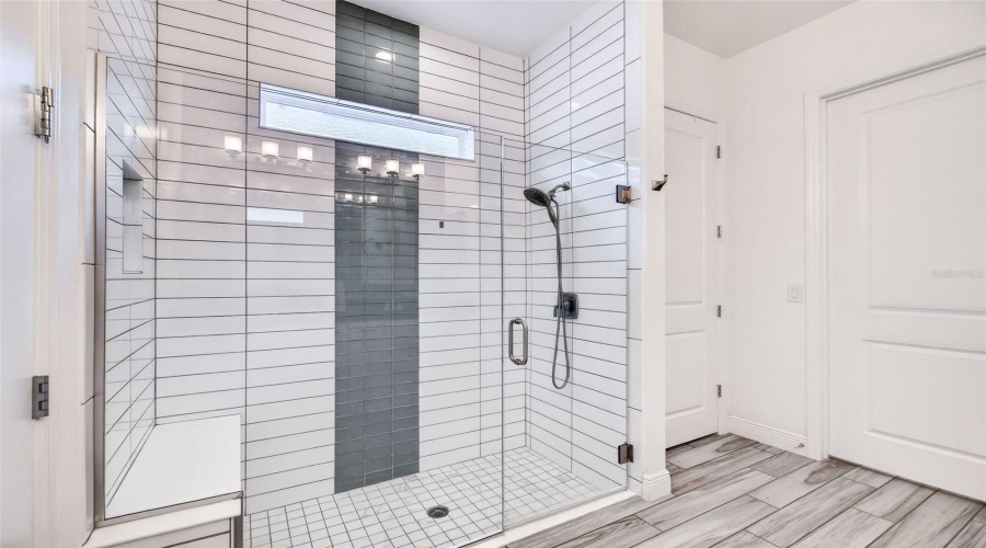 Glass-enclosed shower with upgraded tile