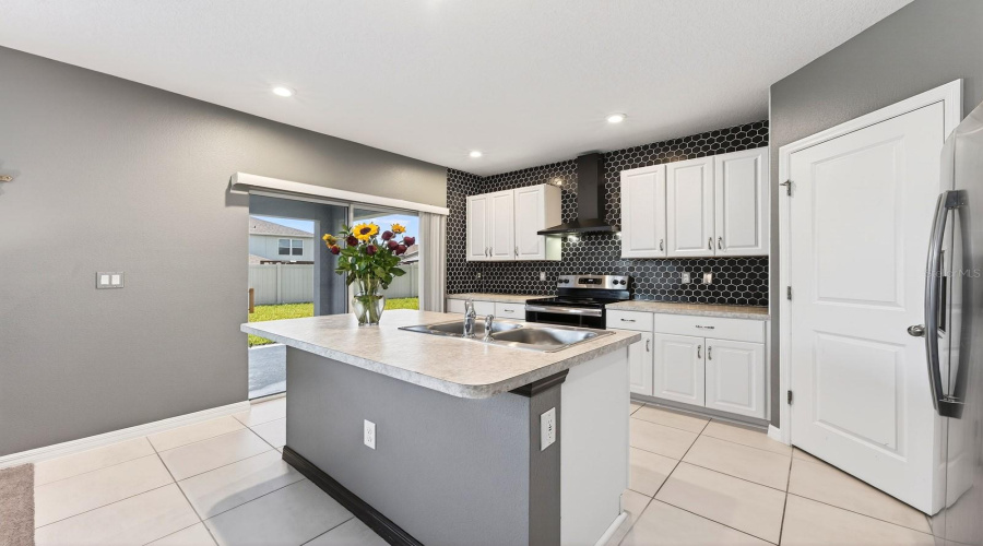 With room for counter-height stools, the Kitchen island serves as a comfortable spot for quick meals or gathering with guests.
