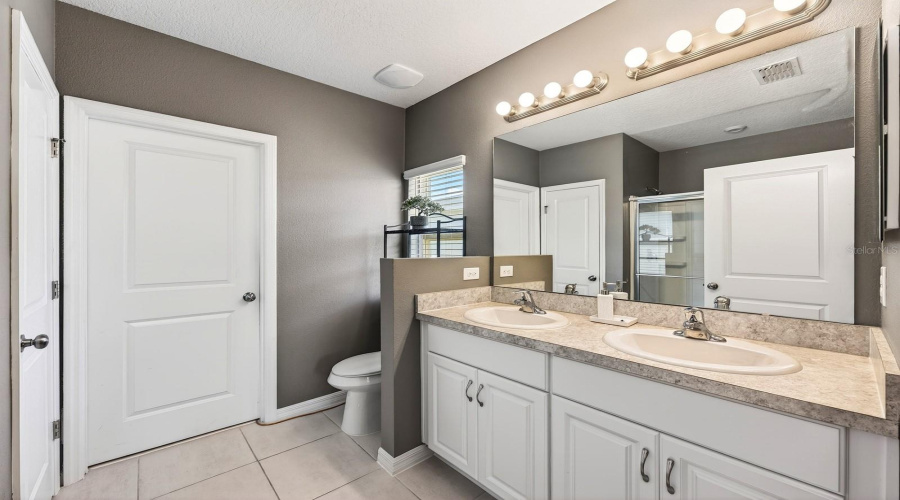 The Primary Bedroom features a GENEROUS WALK-IN CLOSET and an EN SUITE BATH with dual sinks and a step-in shower, creating a peaceful retreat at the end of the day.