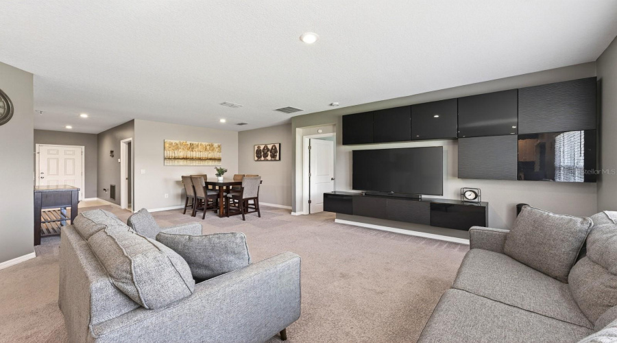 Large windows and sliding glass doors bring in ABUNDANT NATURAL LIGHT, adding to the home’s warm and welcoming atmosphere.