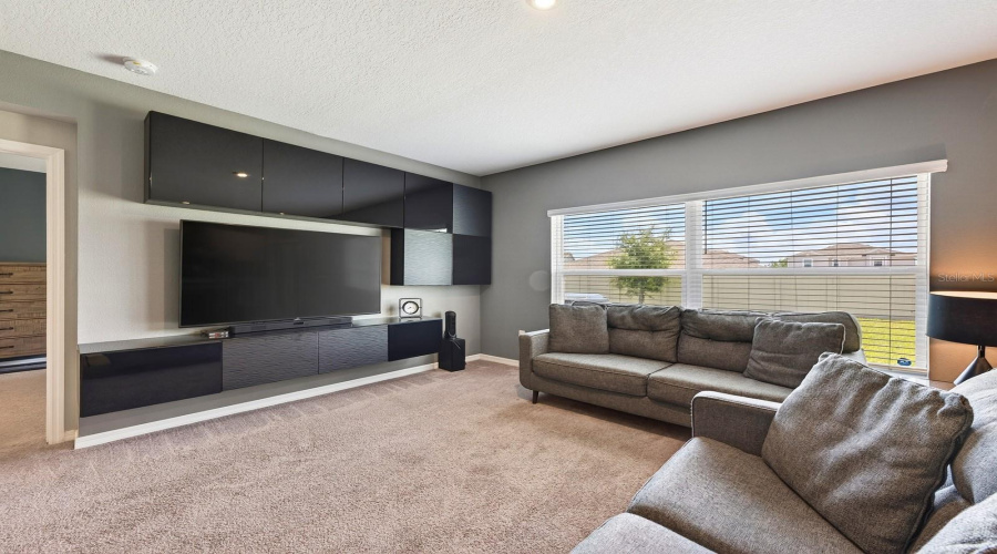 Large windows and sliding glass doors bring in ABUNDANT NATURAL LIGHT, adding to the home’s warm and welcoming atmosphere.