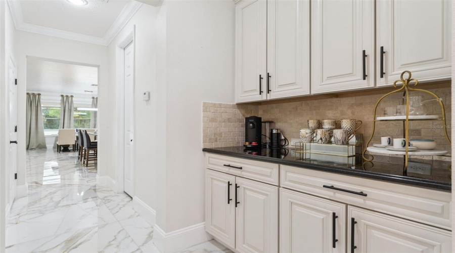 A stylish built-in coffee bar with abundant cabinetry and counter space, creating the perfect spot for morning routines and more storage