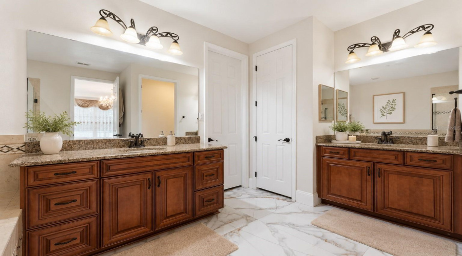 A spacious spa-inspired retreat featuring dual vanities, a soaking tub, a walk-in shower, and a generously sized custom walk-in closet with abundant storage and organization space