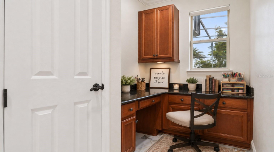 A versatile built-in workspace outside the primary bedroom  featuring extensive cabinetry, generous counter space, and abundant storage, perfect for crafts, homework, studying, or working from home.