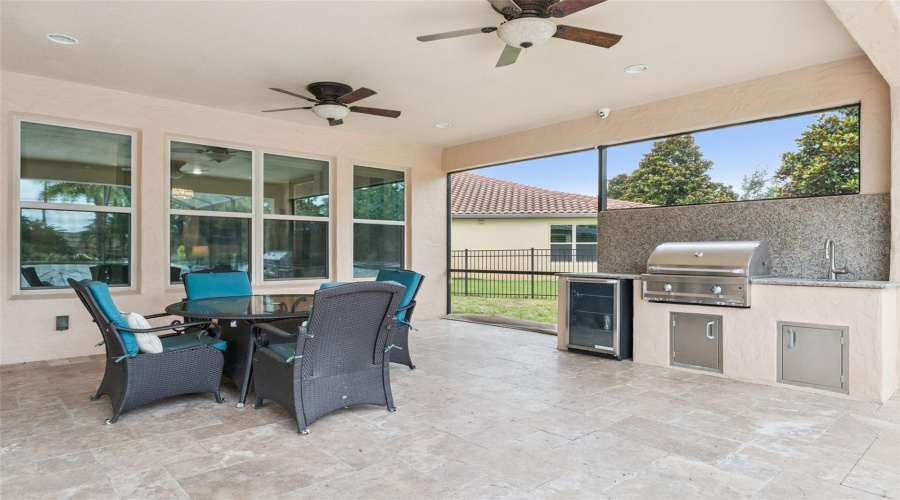 Outdoor kitchen complete with built-in grill, beverage refrigerator, sink, and generous prep space for effortless entertaining