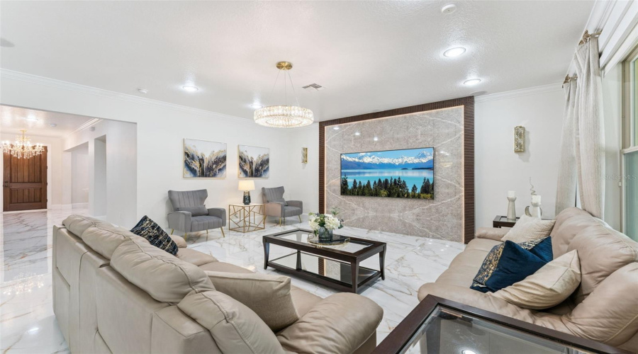 Inviting gathering space featuring a custom designer accent wall with a built-in TV feature, adding warmth, style, and a modern focal point to the home