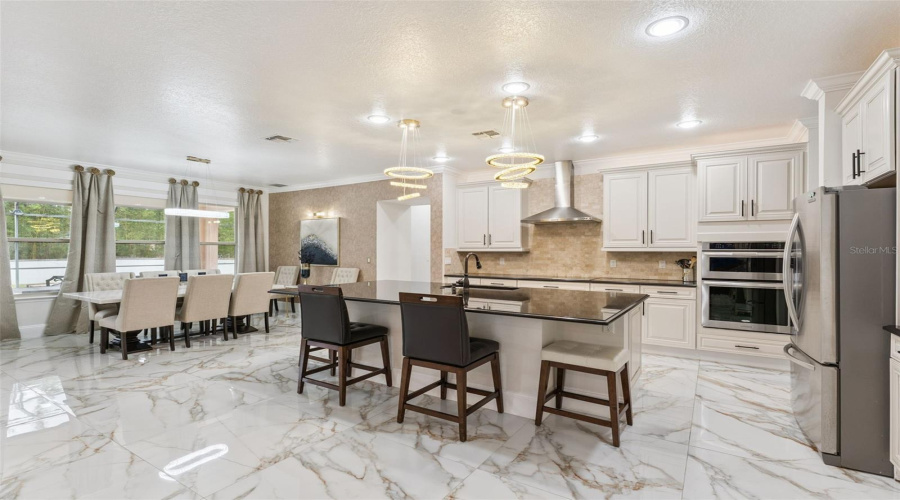 he spacious kitchen seamlessly connects to the breakfast area, creating a functional and inviting space for cooking, dining, and gathering