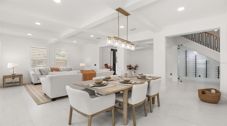 The dining area features a modern linear chandelier, seating for six, and a seamless connection to the living room and foyer.