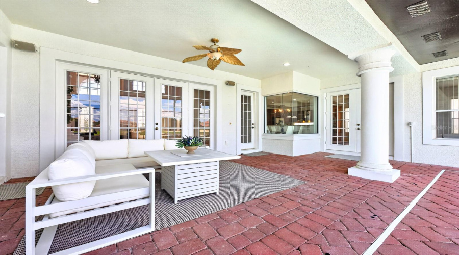 Step out through multiple french doors to your covered, screened in paver patio and pool area.