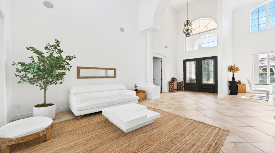 The BREATHTAKING ENTRANCE, highlighted by a dramatic 30-foot ceiling, sets the tone for the elegance found throughout the home.