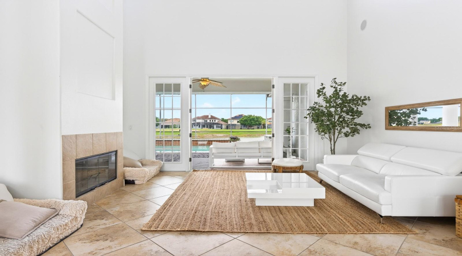The formal Living Room is both elegant and inviting, featuring a COZY FIREPLACE and FRENCH DOORS that open directly to the outdoor living space.