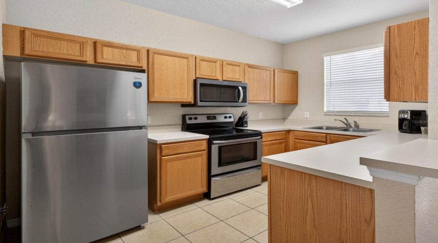The kitchen comes equipped with a refrigerator, microwave, dishwasher, and stove — everything you need for effortless meal preparation.