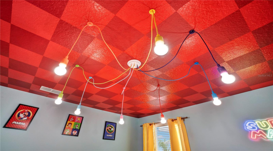 Designer lighting and custom ceiling treatments transform the Rainbow Road Loft into an immersive gaming experience.