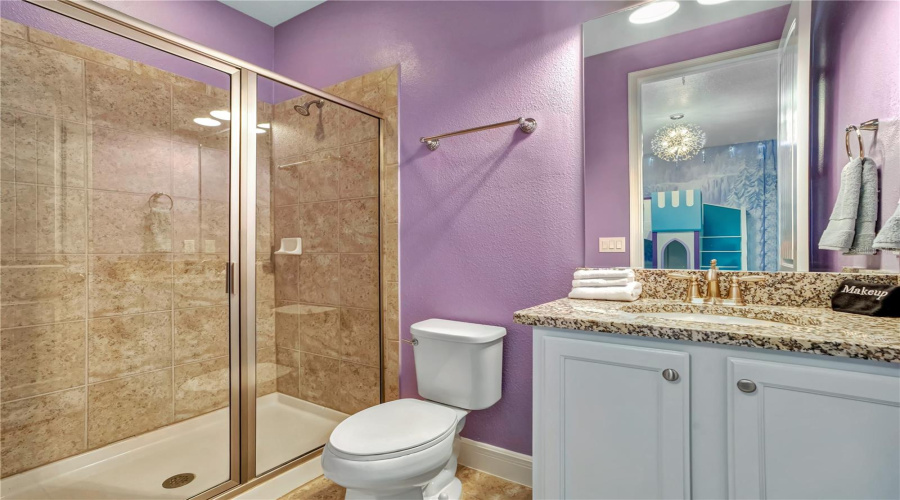 The coordinating Frozen-inspired bathroom continues the magical experience with playful colors, modern finishes, and a spacious walk-in shower.