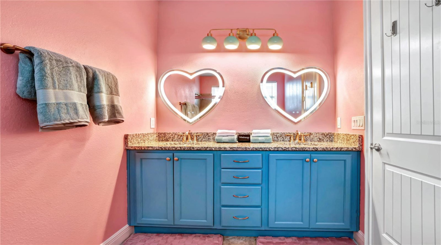 The coordinating Barbie-inspired bathroom continues the glamorous theme with custom lighting, designer vanities, and playful finishing touches.